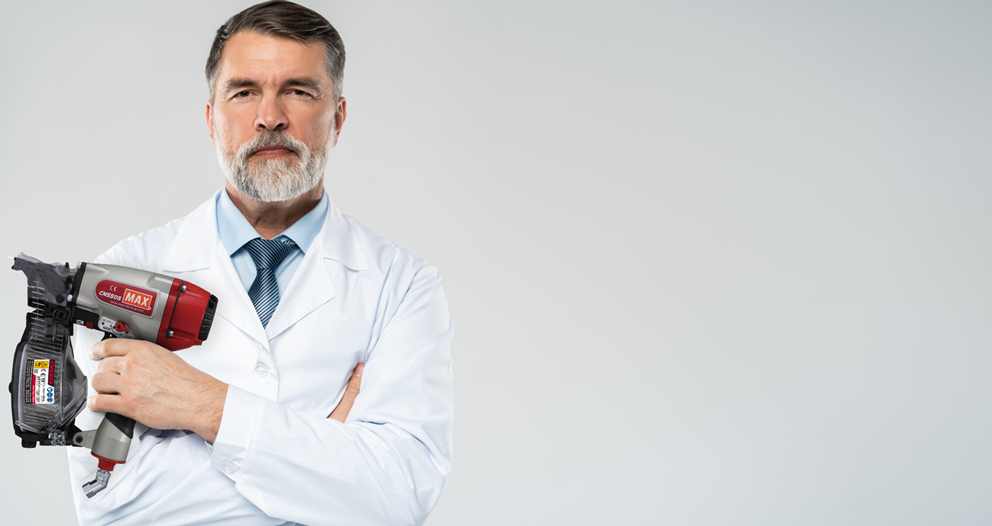 Cheerful mature doctor posing and smiling at camera with MAX 8bar nailer